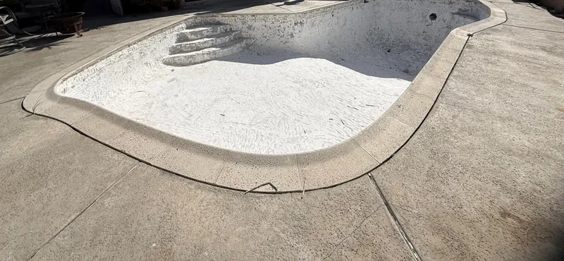 Empty pool with the steps and basin freshly coated in white plaster before refilling